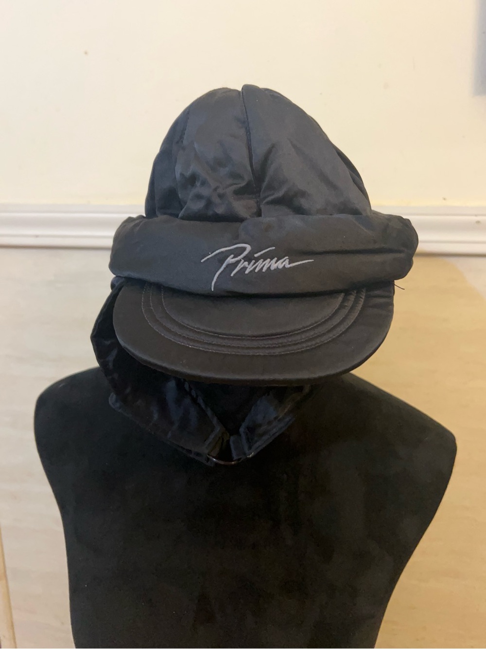 Prima padded trapper cap featuring a curved visor and integrated ear flaps.